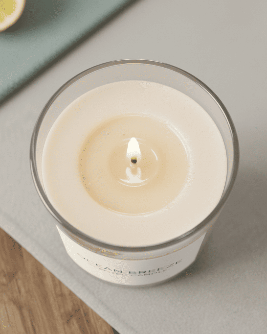 Candle in a glass jar with a white label on a wooden surface